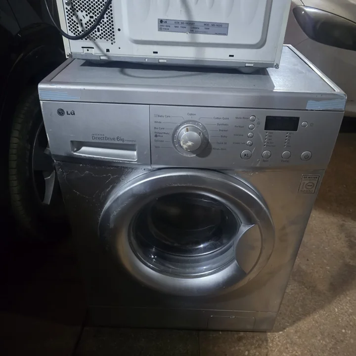 Silver LG front-load washing machine on a repair visit