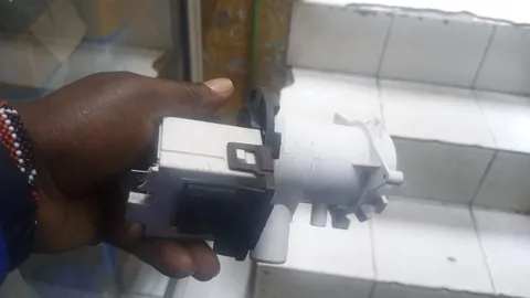 Technician holding a washing machine drain pump